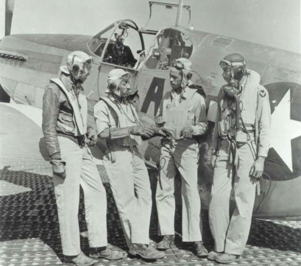 Clarence Dart (L) pictured with fellow Tuskegee Airmen (L-R from Dart: Elwood Driver, Herbert Hus-ton, Elva Temple) discussing how Elwood had just shot down an ME 109. May 1944. Photo provided. 