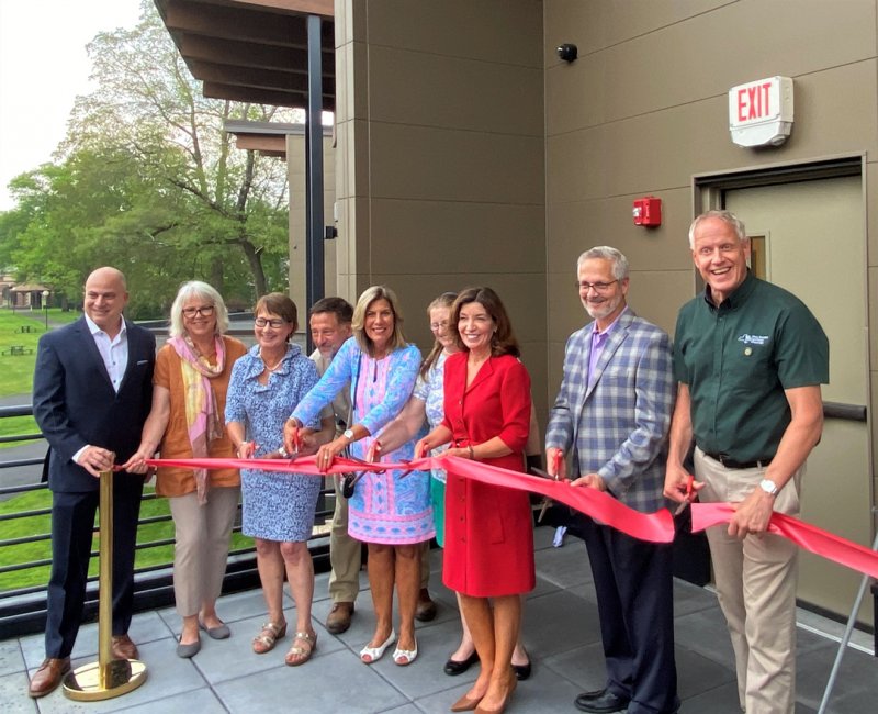 Lieutenant Governor Kathy Hochul (at center in red) joins local and regional representatives from the worlds of art, business and politics at a ceremonial ribbon-cutting of The Pines@SPAC on July 27, 2021. Photo by Thomas Dimopoulos.