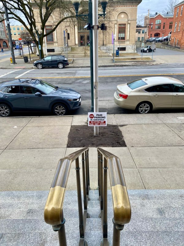 A portable sign stating opposition to a paid parking proposal outside Saratoga Springs City Hall on March 4, 2024. Photo by Thomas Dimopoulos. 